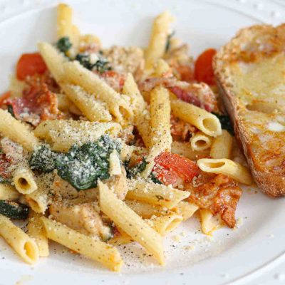 chicken and bacon pasta with spinach and tomatoes in garlic cream sauce